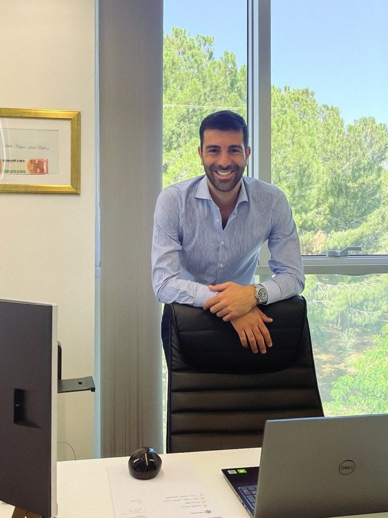 Andreas Kapsos, CEO of Match-Prime liquidity provider, standing behind a chair in his office